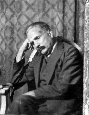 Muhammad Iqbal seated, resting his head on his hand in thought