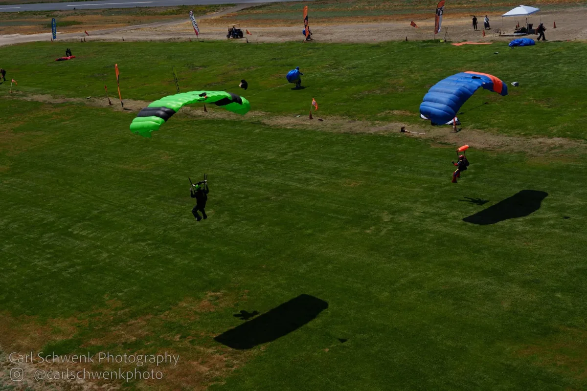 Parachutes approaching the grassy landing area